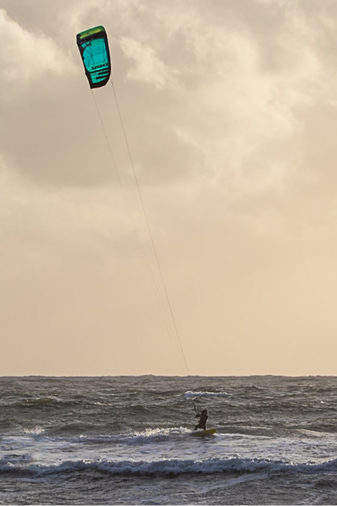A kitesurfer surfing at Le Mentor under supervision